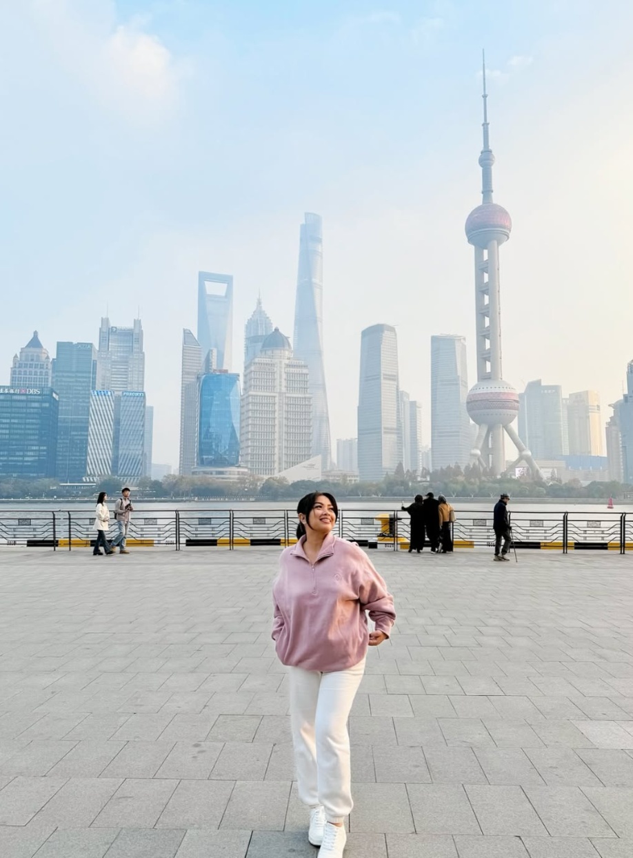 Jhayde standing on the Bund with the Shanghai skyline behind her